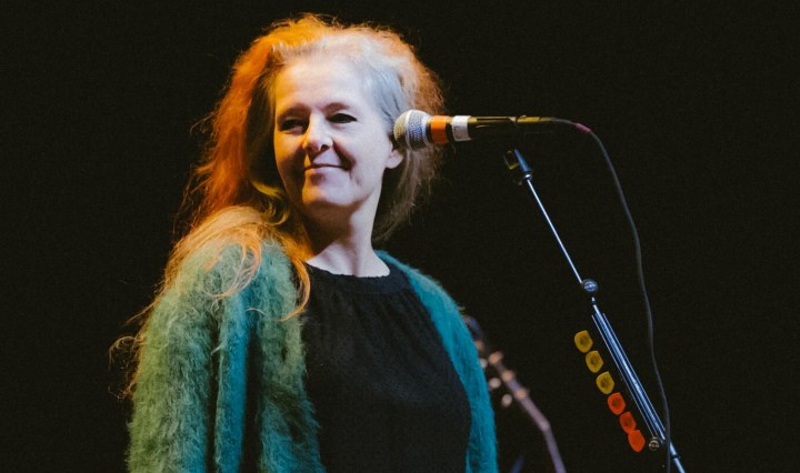 Neko Case standing behind a microphone